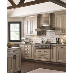 a kitchen with white cabinets and wood floors