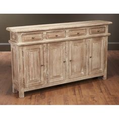 an old white wooden cabinet with four drawers and two doors on one side, sitting on a hard wood floor