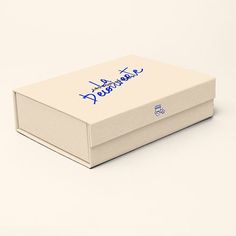 a white box with blue writing on the lid and bottom, sitting on a plain surface