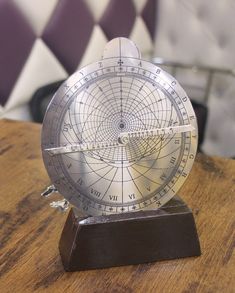 a metal compass sitting on top of a wooden table