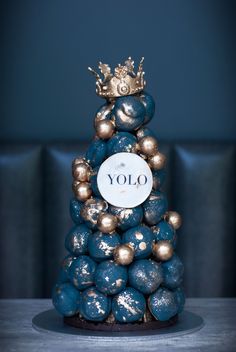 a blue and gold christmas tree made out of chocolate balls with the word yolo written on it