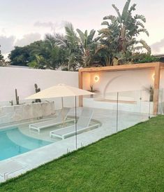 an outdoor swimming pool surrounded by lush green grass