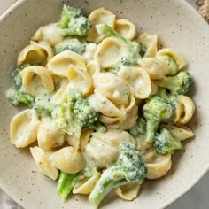 a white bowl filled with pasta and broccoli