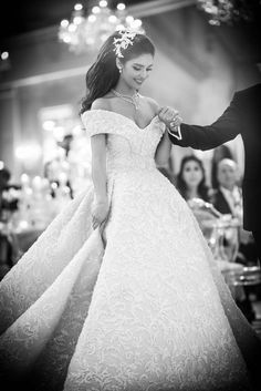 a woman in a wedding dress holding the hand of a man