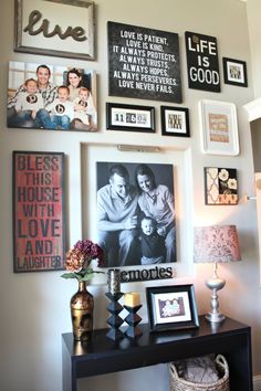 a black table with pictures on the wall and framed photos above it, along with other items