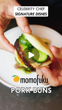 a person is holding a hamburger with pickles on it and the caption reads celebrity chef signature dishes momofuk pork buns