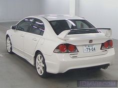 the back end of a white car parked in a garage