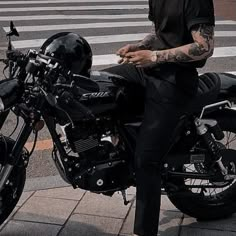 a man sitting on top of a black motorcycle