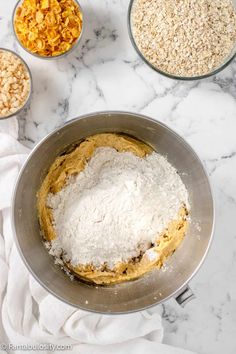 the ingredients are in bowls on the marble counter top, including oatmeal and raisins