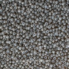 close up view of gray beads with holes in the middle and on the outside, as if they were made out of metal