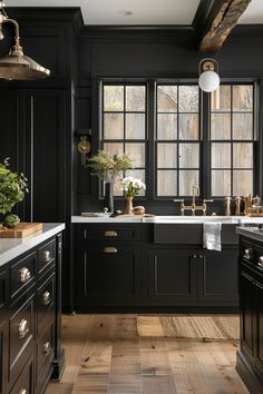 a kitchen with black cabinets and wooden floors