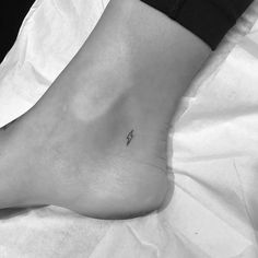 a small lightning bolt tattoo on the ankle