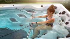 a woman in a large hot tub with fishing rods on the handle and poles attached to it