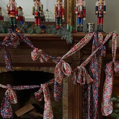 christmas decorations are hanging on the mantle in front of a fire place with nutcrackers