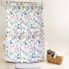 a shower curtain with flowers on it next to a basket