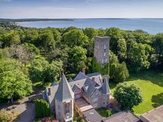 an aerial view of a large house with trees and water in the backround