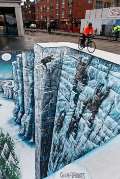 a man on a bicycle rides over a wall with an image of a castle in the middle