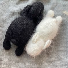 two black and white stuffed animals laying next to each other