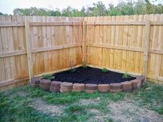 a wooden fence with a garden bed in the middle