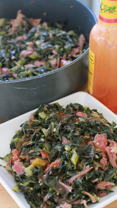 a plate of greens next to a pot of orange juice