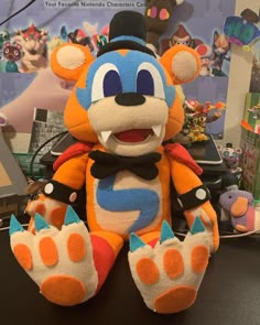 an orange and blue stuffed animal sitting on top of a table