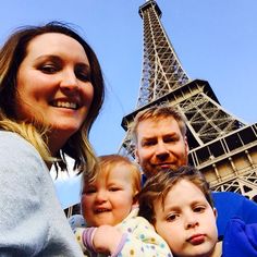 a family poses in front of the eiffel tower