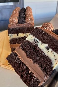 a chocolate cake with white frosting and oreo cookies on the top is cut in half