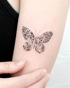 a woman's arm with a butterfly tattoo on the left side of her arm