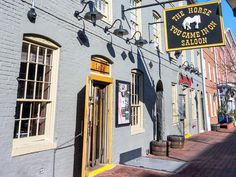 the horse too come my saloon sign is hanging from the side of an old building