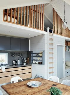 an open kitchen and dining room area with stairs leading up to the loft above it