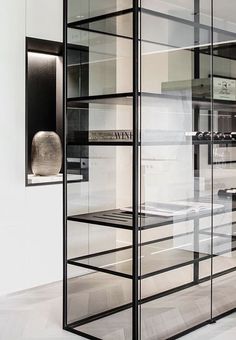 an empty kitchen with black and white decor on the walls, along with glass partitions