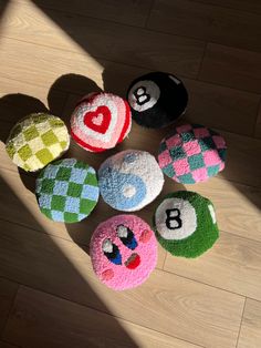 several different colored balls on the floor with numbers and letters painted on them, all arranged in a circle