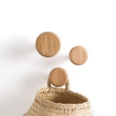 three round wooden knobs on top of a basket