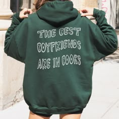 a woman wearing a green hoodie that says the best boyfriends are in books