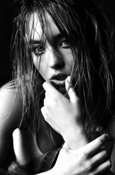 a black and white photo of a woman with wet hair