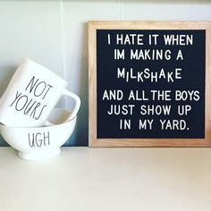 two coffee mugs sitting on top of a table next to a sign that says i hate it when im making a milkshake and all the boys just show up in my yard