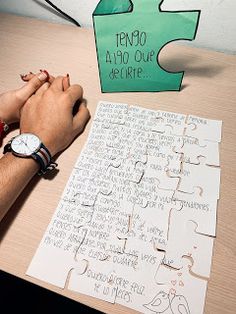 a person sitting at a table with a piece of paper on it and a puzzle in front of them