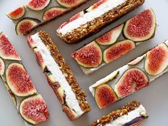 sliced figs are arranged on a plate with cream cheese and granola toppings