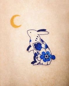 a blue and white bird with flowers on it's body sitting in front of the moon