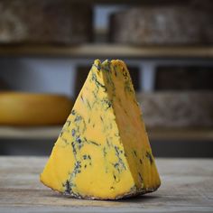 a piece of cheese sitting on top of a wooden table