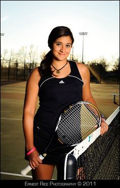 a woman holding a tennis racquet on top of a tennis ball racket