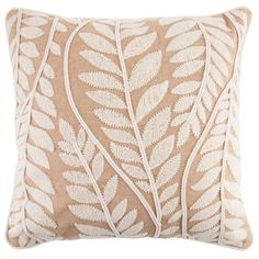 a beige and white pillow with leaves on it