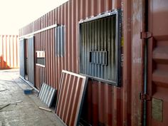 the side of a red shipping container with metal doors and windows on it's sides