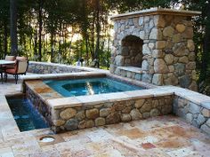 an outdoor hot tub surrounded by stone walls