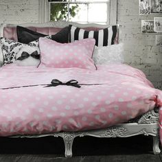 a bed with pink and white polka dot comforter, pillows and pillowcases