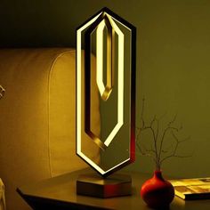 a mirror sitting on top of a wooden table next to a vase and lamp in front of it