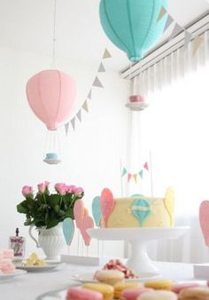 a table topped with lots of cakes and cupcakes next to a vase filled with flowers