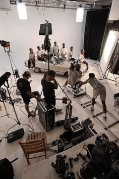 a group of people in a room with cameras and video equipment on the floor next to each other