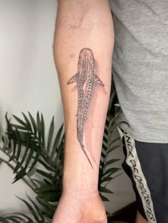 a man with a tattoo on his arm is holding an elephant's tail in front of him