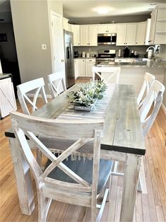 a dining room table with chairs and a bowl of flowers on top of the table